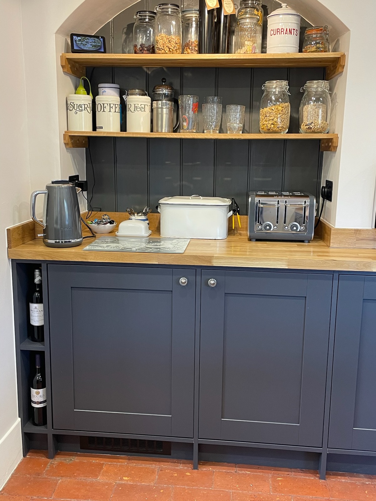 Navy shaker pantry with open shelves stacked with jars