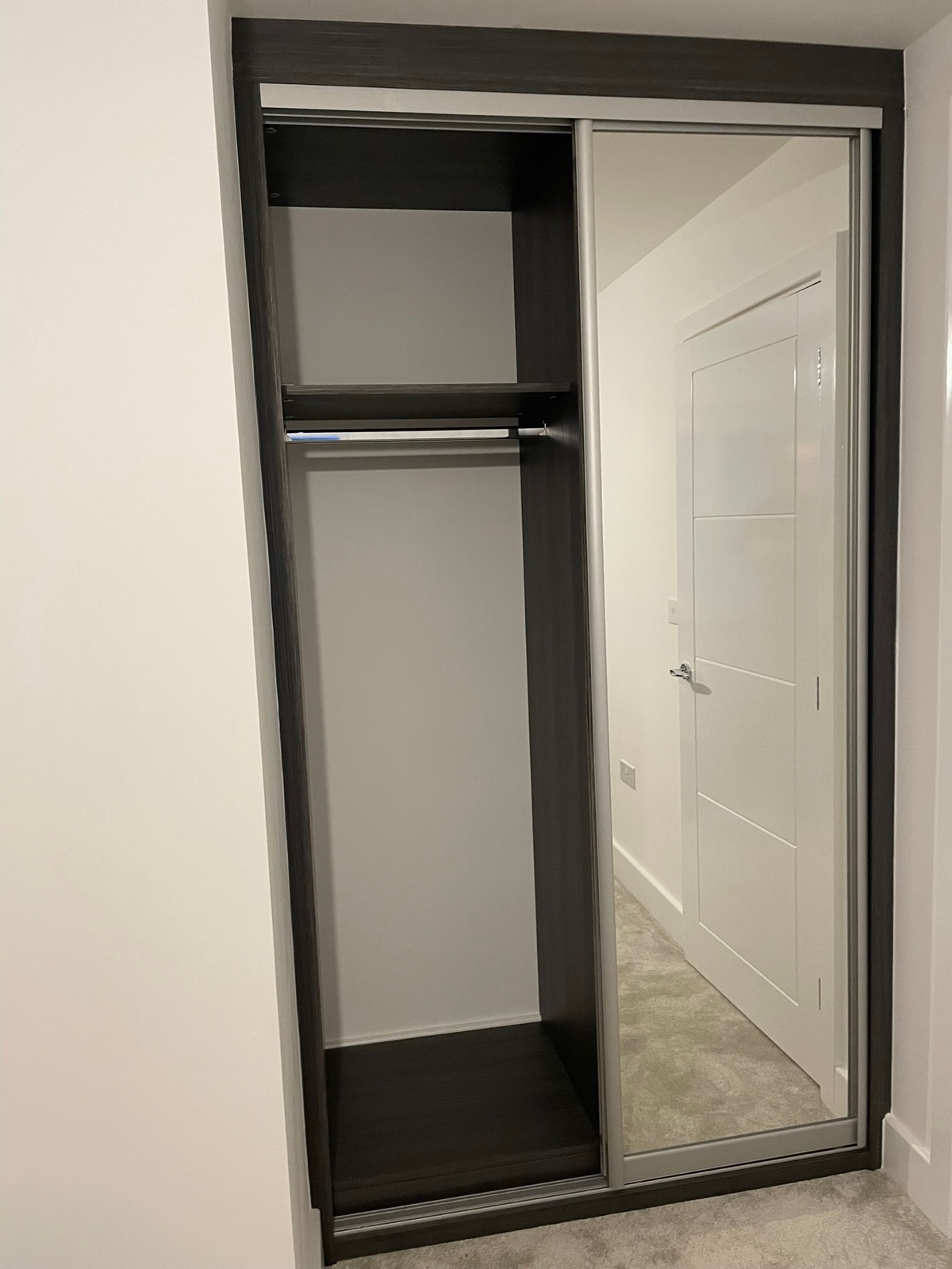 Wardrobe charcoal frame mirror sliding open shelves, made and fitted by Sussex Design Interiors