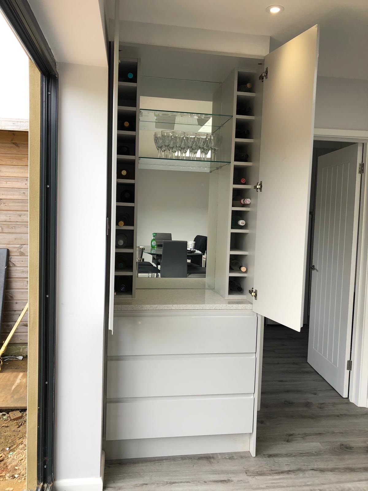 Wine rack cabinet mirrored drawers, made and fitted by Sussex Design Interiors